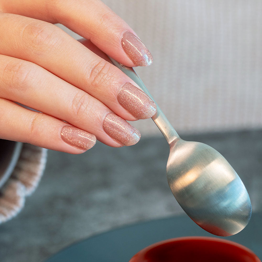 manicured hand holding a spoon